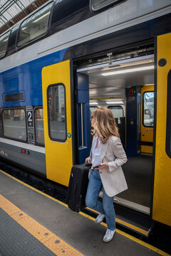 Mature woman boarding train at railway station