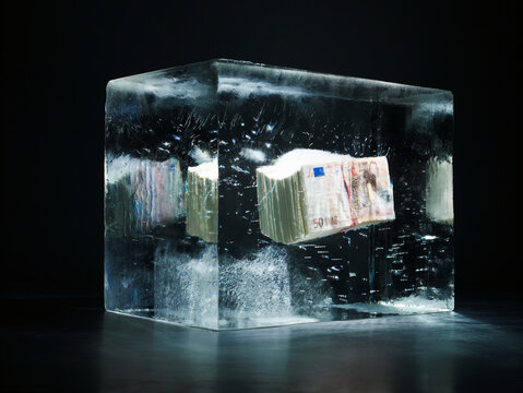 Bundle of 50 euro banknotes frozen in an ice block