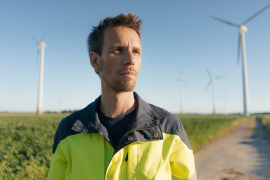 Portrait of an engineer on field path at a wind farm