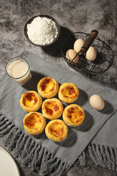 Portuguese Custard Tarts Past&eacute;is de Nata with Baking Ingredients on Rustic Kitchen Counter