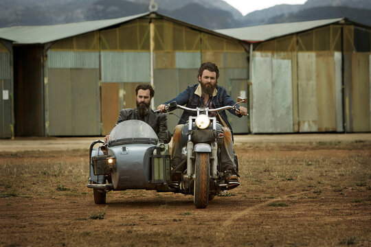 Two men with full beards in motorcycle with sidecar