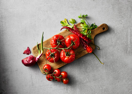 Dried tomatoes and vegetables on a cutting board directly above