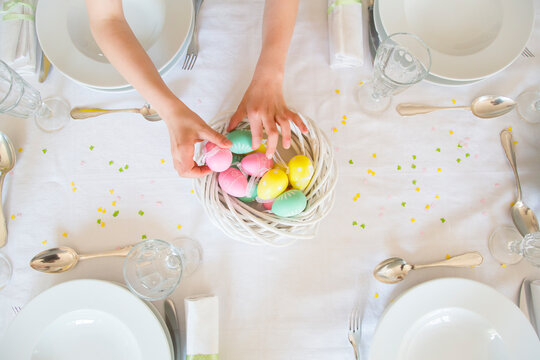 Little girl decorating dining table with Easter eggs