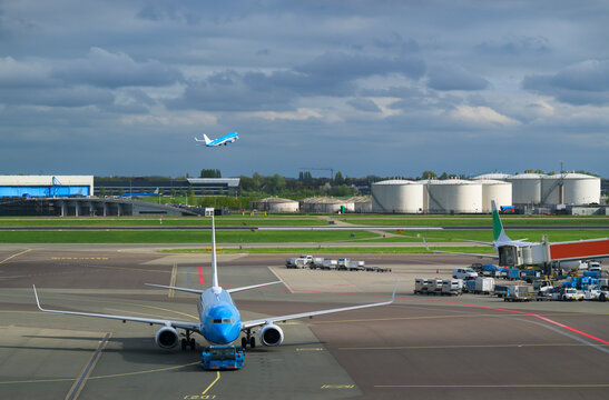 Blue airplane towed on airport tarmac in Amsterdam Netherlands