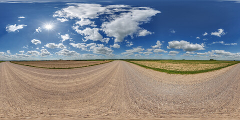 Obraz premium blue sky hdri 360 panorama with awesome clouds on gravel road among fields in spring day in equirectangular full seamless spherical projection, for VR AR content or skydome replacement