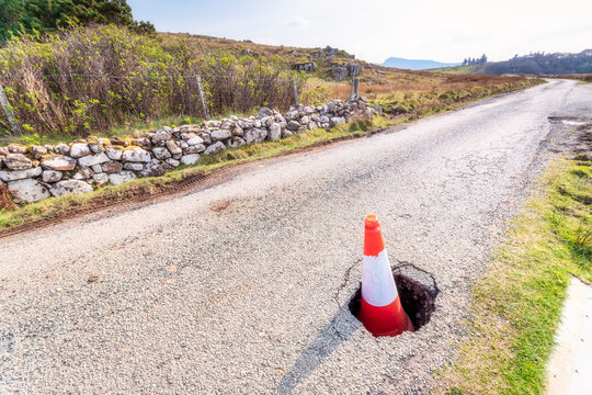 Traffic cone in pot hole on road at Isle of Skye, Highlands, Scotland, UK