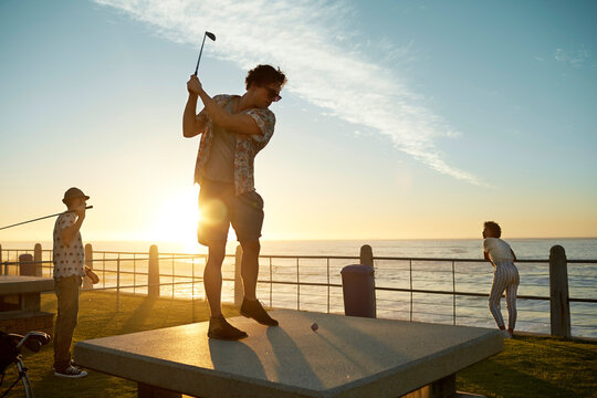 Friends playing urban golf at the coast