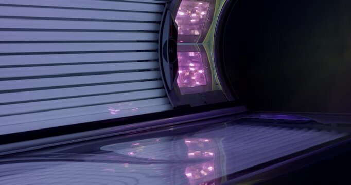 An open tanning bed with ultraviolet lamps in a modern spa or beauty salon