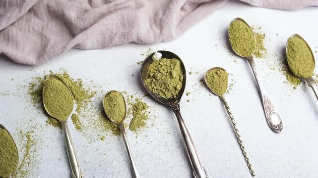 Matcha powder on spoons arranged on a surface