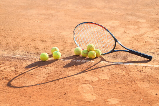 Racket with tennis balls on court