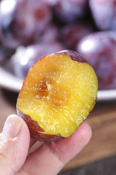 Fresh Cut Xinjiang Prune Showing Golden Sweet Flesh in Hand - Studio Food Photography
