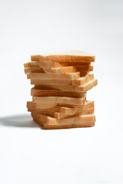Multiple slices of soft white bread arranged in an orderly stack on a white background, perfect for bakery, breakfast, and food product concepts.