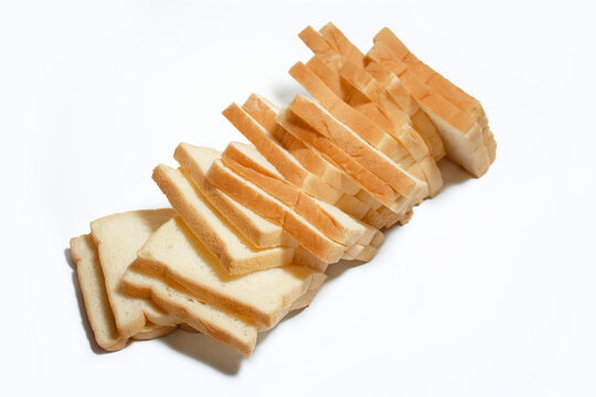 Top view of several sliced white bread pieces neatly arranged in a row on a clean white background. Fresh sandwich bread with evenly cut slices, isolated with a minimalist composition.