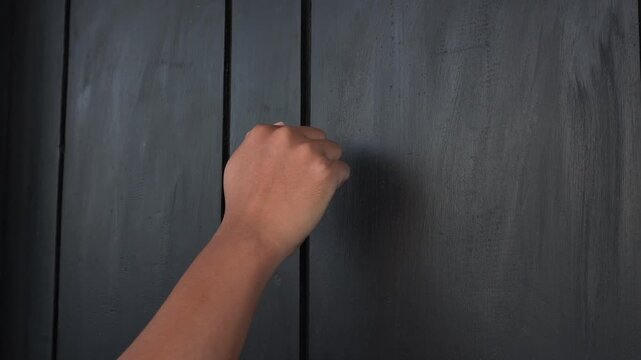 An Asian hand was knocking on the black door