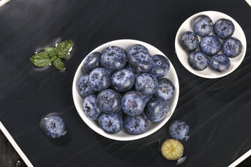 Fresh Blueberries in White Bowls with Mint on Dark Background - Healthy Organic Fruit Concept © QuangVinh