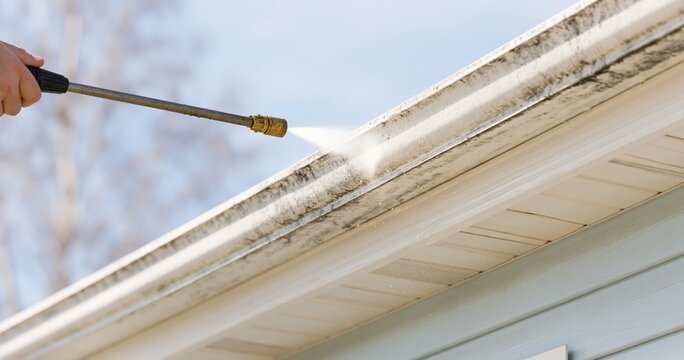 Pressure washing dirty house gutters