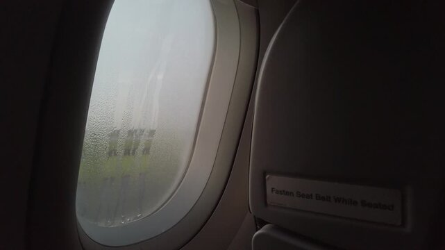 Raindrops dew on planewindow surface, A dewey morning sunrise as seen through an airplane window. travel vacation holiday begin background