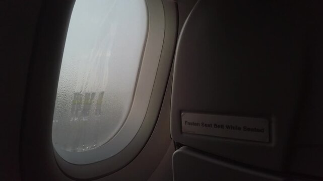 Raindrops dew on planewindow surface, A dewey morning sunrise as seen through an airplane window. travel vacation holiday begin background