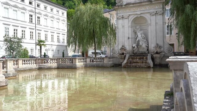 Antique Water Neptune Fountain in Austria Salzburg city Baroque Architecture, Marble Sculpture and Water waves Reflection pond.