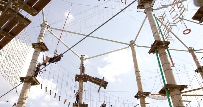 Person ziplining through the air on an outdoor high ropes obstacle course