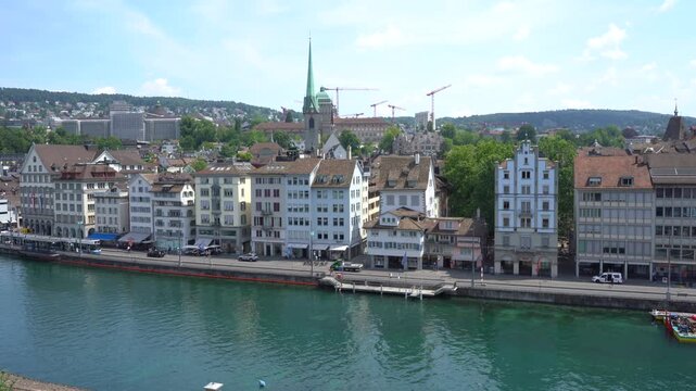 Panoramic View of Zurich city Old Town Waterfront architecture with Limmat River water and Church in Switzerland. Houses street road cars