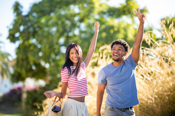 Obraz premium Happy couple celebrating together in sunny park