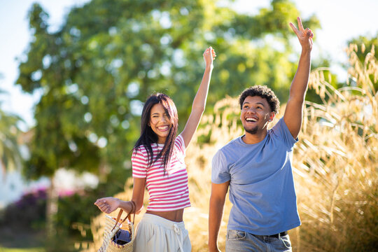 Happy couple celebrating together in sunny park