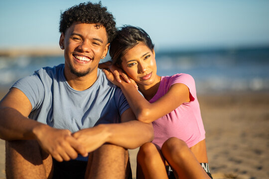 Romantic young couple embracing on beach at sunset