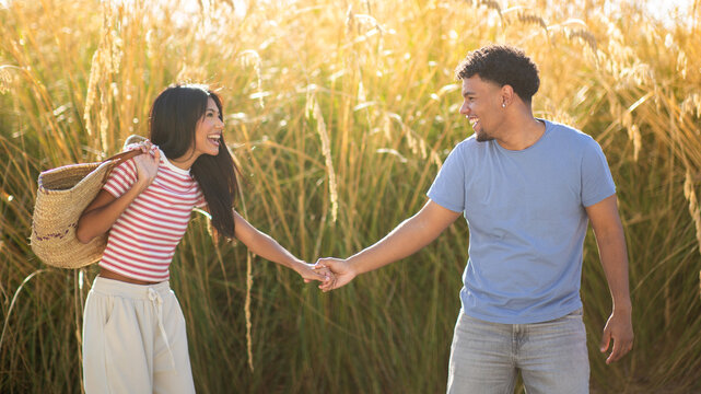 Smiling couple holding hands in golden sunlight