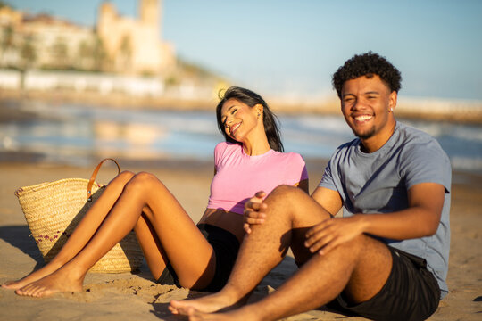 Happy young couple relaxing together on sunny beach