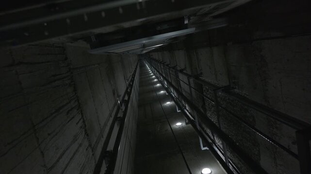 Elevator shaft interior with guide rails and maintenance lighting
