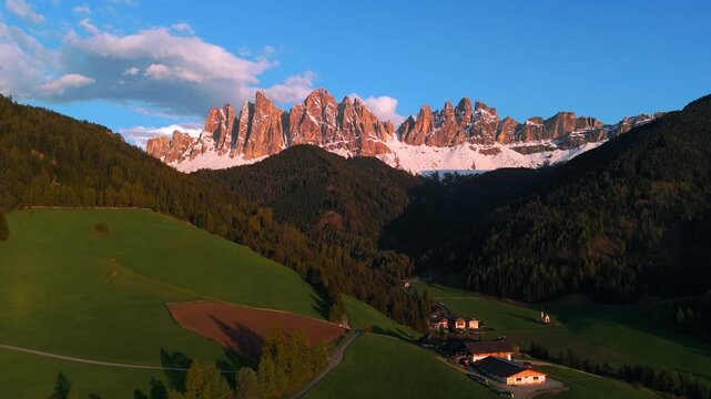 Radiant red and orange sunset colors at dramatic Odle mountains in Puez-Geisler. Italian Dolomites. Alpenglow