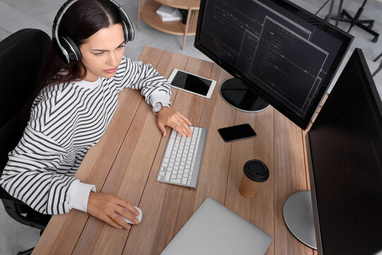Pretty young female programmer working in office