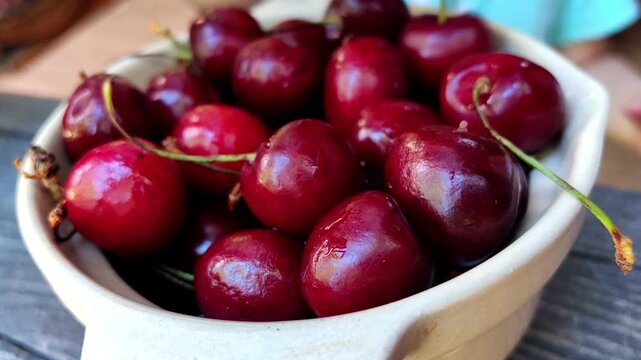 Children repeatedly pick juicy cherries from a ceramic bowl, healthy summer snack, family sharing, countryside lifestyle, seasonal harvest.