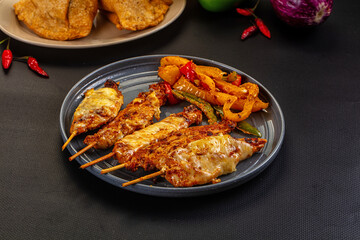 Fototapeta premium Grilled chicken skewers with bell peppers on dark plate