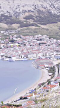 Person looking Pag city from above refocus from person to city