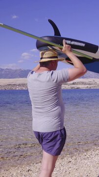 Couple on vacation carry sup over head