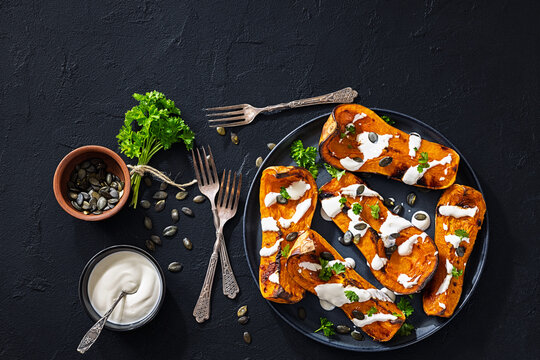 Baked butternut squash halves with yogurt sauce