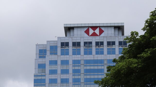 HSBC Bank Skyscraper Exterior Against an Overcast Sky Partially Obscured By a Tree on June 28 2026 in Bangkok, Thailand.