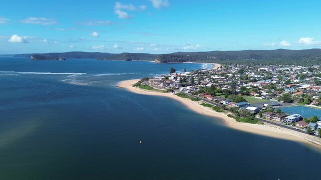 drone view Ettalong beach NSW Australia.View of the bay with boats and a town by the water on a sunny day near a large hill in New South Wales
