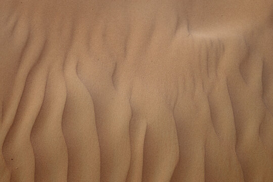 Closeup of sand of sand dunes located in the United Arab Emirates. Color image showing the beautiful texture of the sand after wind.