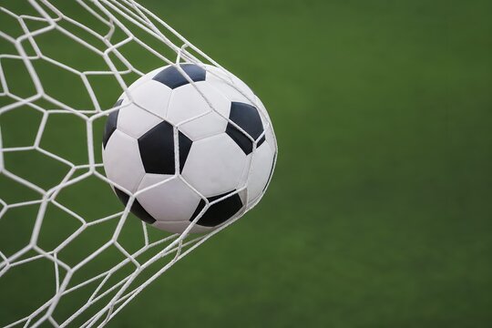 Soccer ball in net, goal scored, sports action.