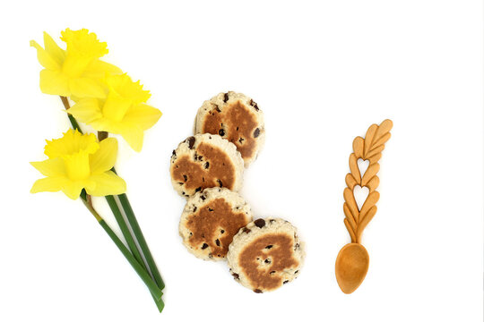 National Symbols of Wales spring daffodil flower St Davids Day emblem, Welsh cakes, carved wheat lovespoon symbol token of love on white background.