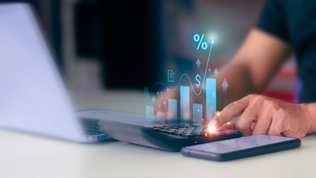 Businessman using calculator with virtual financial growth graph and interest rate percentage icon.