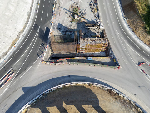 Aerial view of road construction site with concrete formwork, steel reinforcement, and heavy machinery at a highway junction in Istanbul, Istanbul, Turkiye.
