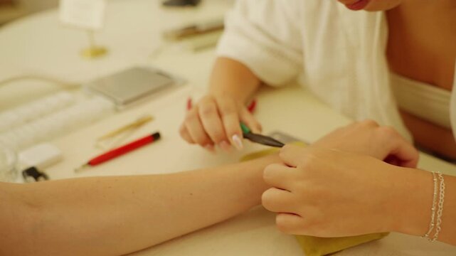 Jeweler crafting permanent bracelet on customer's wrist