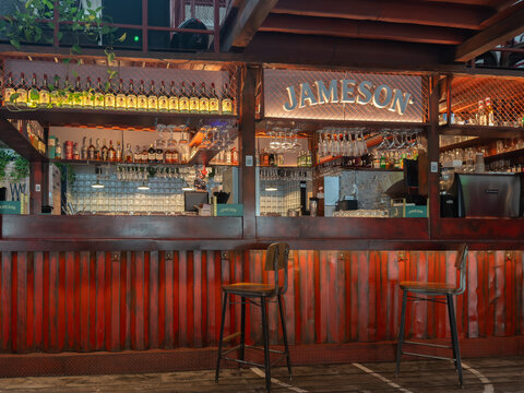 Kyiv, Ukraine - March 21, 2026: A Jameson branded bar interior features red metal siding and high stools with wooden seats to establish a classic rustic pub atmosphere today