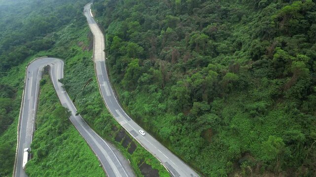 Traffic Winds Up And Down The Hai Van Pass Green Jungle Danang Vietnam Drone Track Back 4K 30FPS