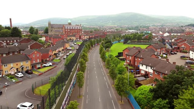 Advancing 4K 60FPS aerial video of the Belfast Peace Wall and Peace Line in Belfast, Northern Ireland in the UK - a barrier separating the Protestant and Catholic communities. Filmed at early evening.