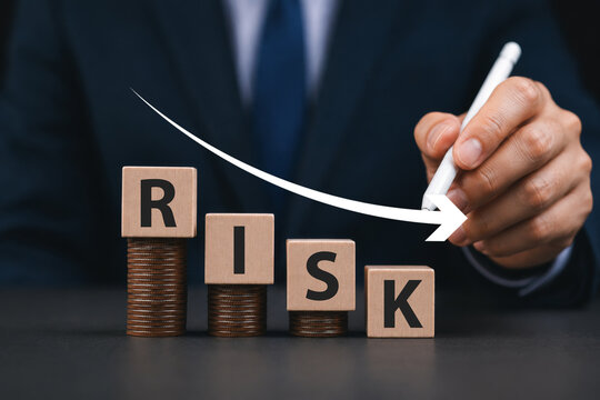 Risk wording on decreasing coins stacking with down arrow for financial banking risk analysis and management ,Low risk low return concept.